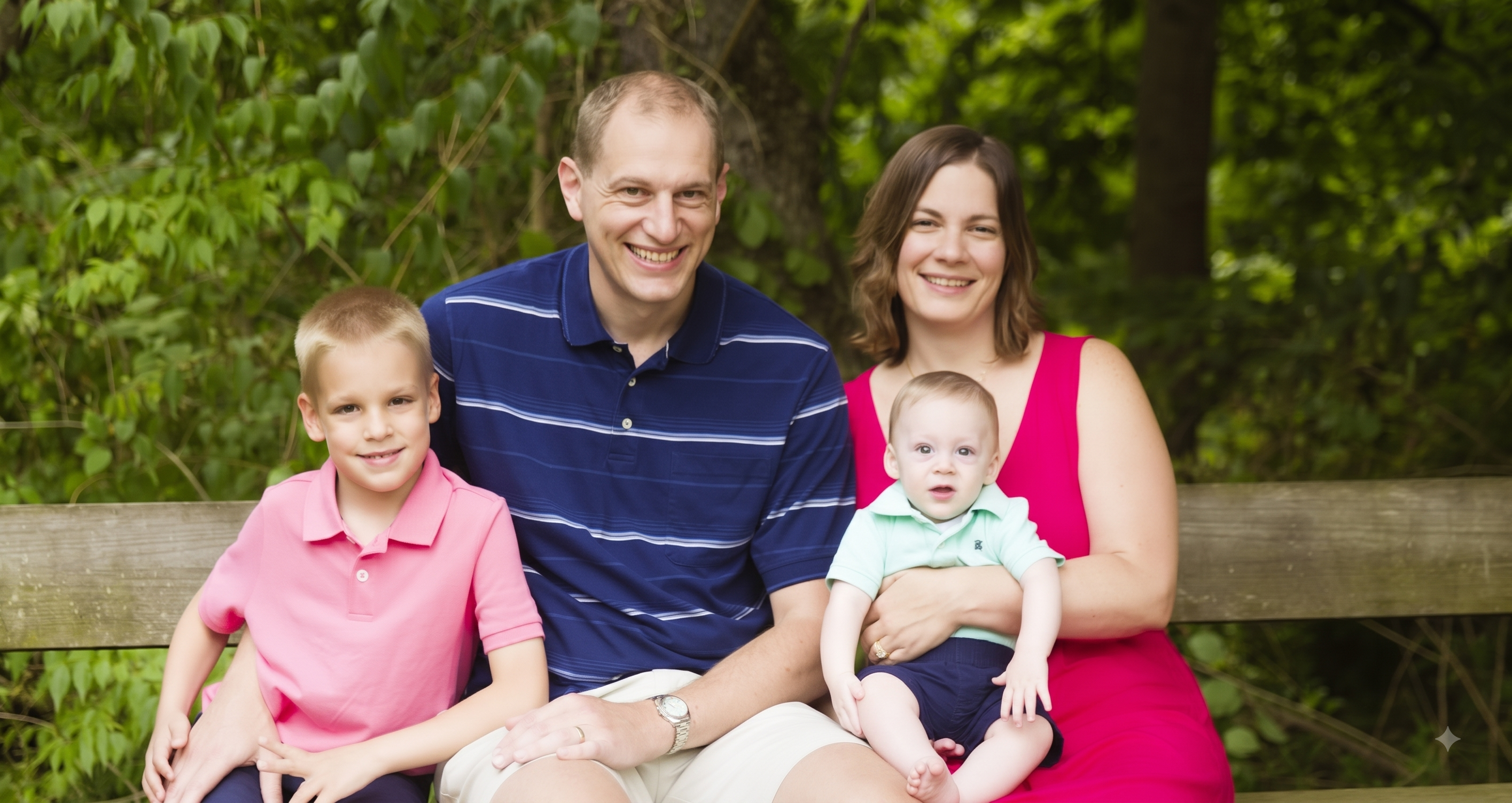 A family of four on a bench in the woods