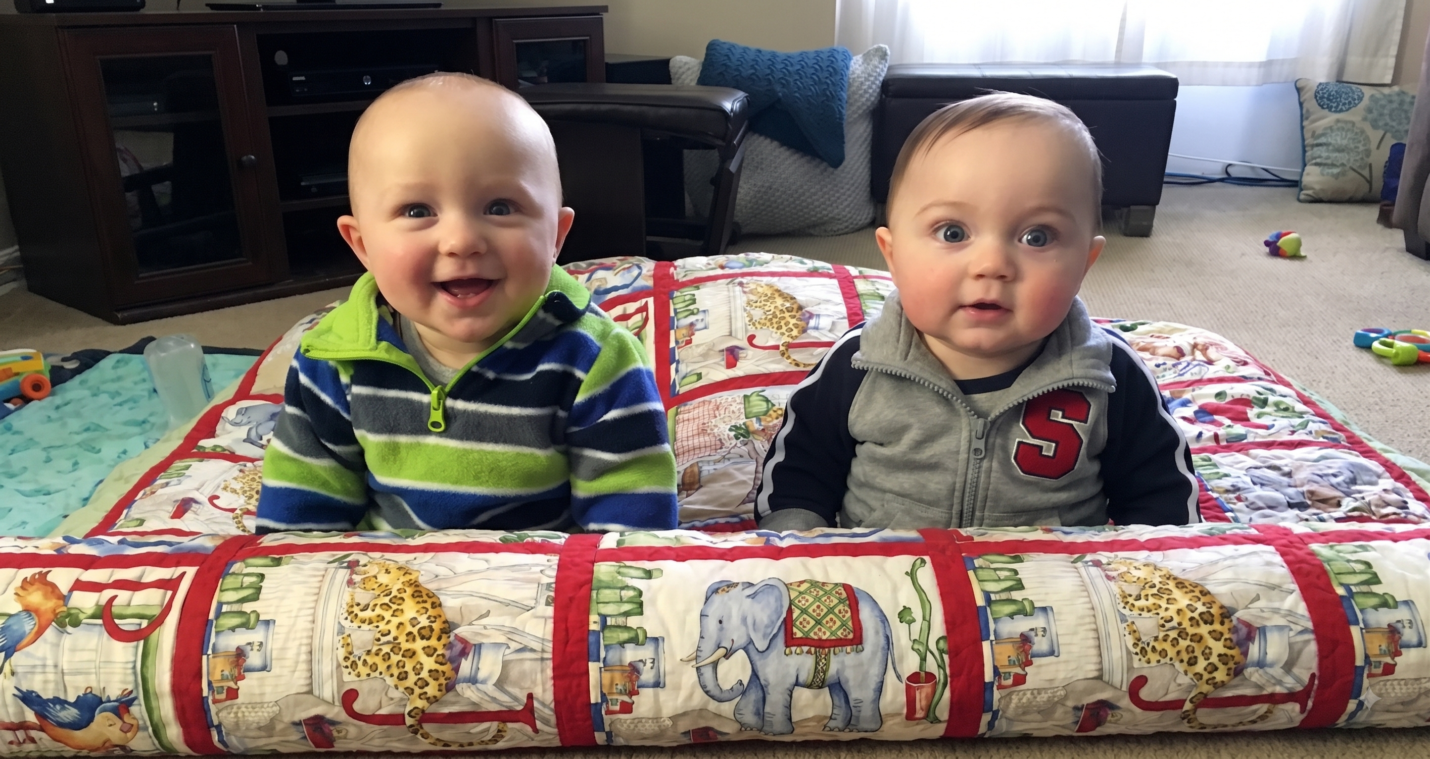 Two happy babies on a quilt