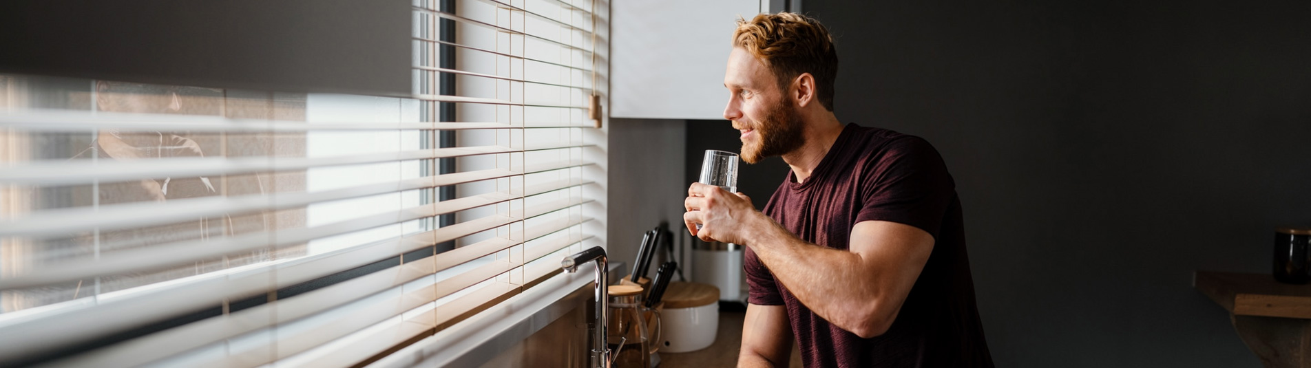 Man enjoying a glass of clean filtered water in his kitchen