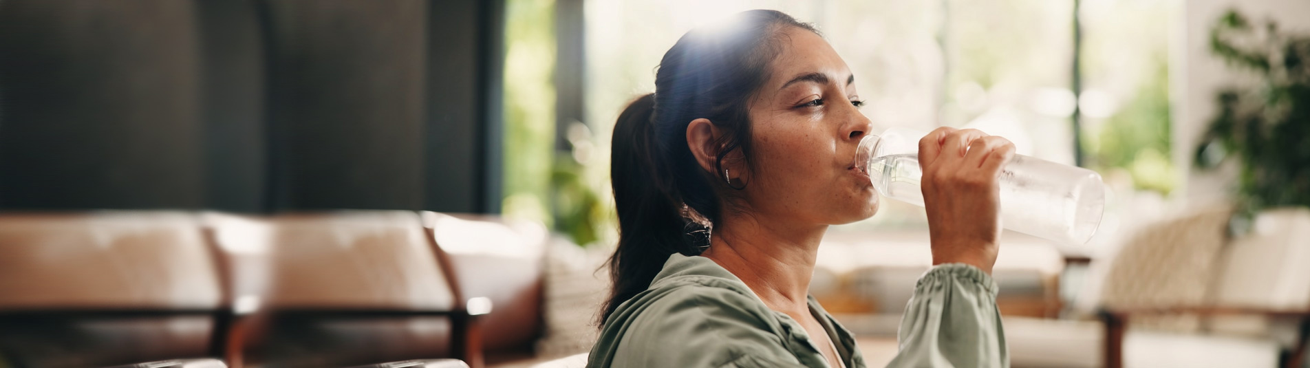 Woman drinking clean, soft water at home