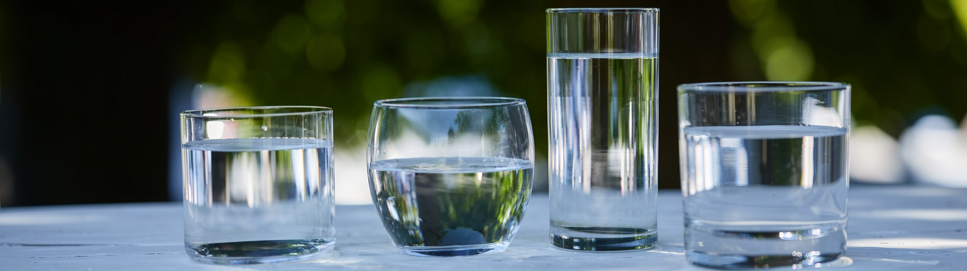 Four glasses of clear water on a table