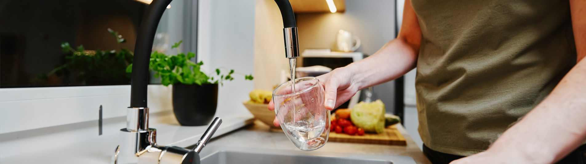 Filling a glass with clean filtered water at the kitchen tap