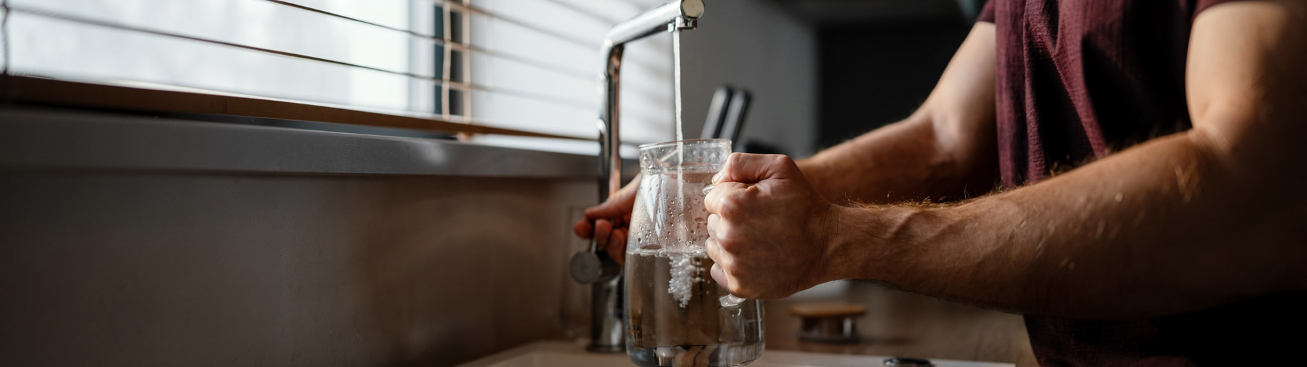 Filling a glass of clean water from the kitchen tap